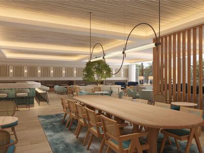 Espace lounge d'hôtel moderne et lumineuse avec grandes tables en bois, chaises et luminaires imposants.