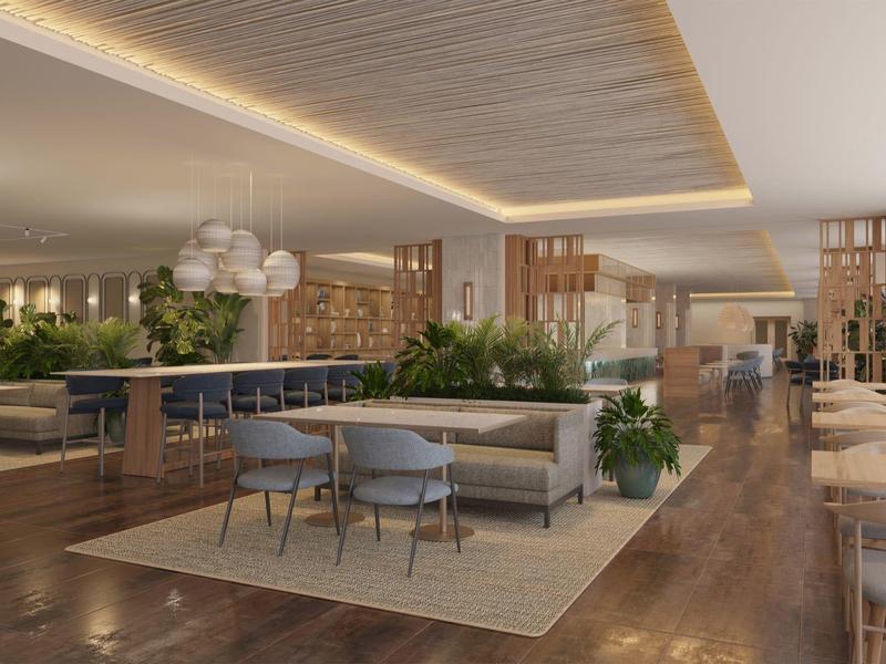 Restaurant moderne et ouvert avec sols en bois, grandes fenêtres et zones de sièges élégantes avec des plantes.