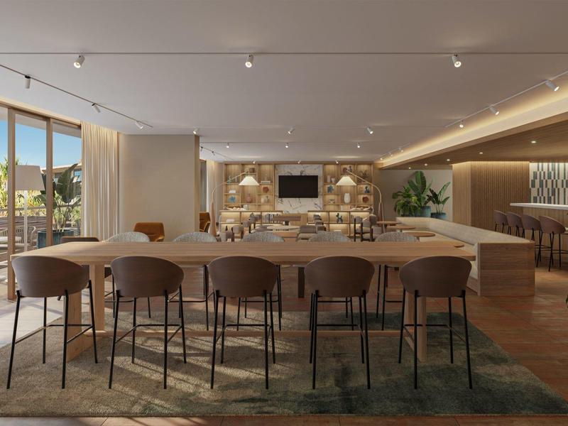 Salle à manger moderne avec grande table ronde et chaises, accès à la terrasse extérieure.