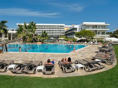 Moderner Hotelpool mit Liegestühlen, Palmen und Gästen an einem sonnigen Tag