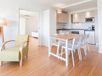 Hell eingerichteter Wohn- und Essbereich mit Holzfußboden und moderner Küche