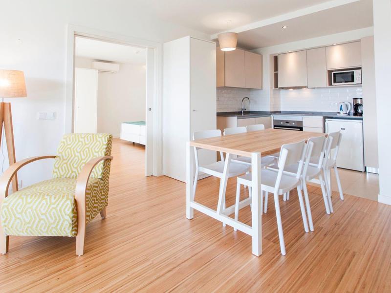 Hell eingerichteter Wohn- und Essbereich mit Holzfußboden und moderner Küche