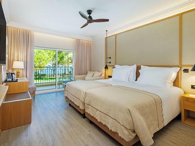 Helles Hotelzimmer mit Doppelbett, Balkon und modernem Dekor.