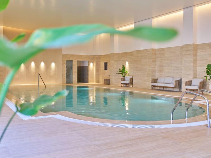 Entspannte Innenpoolanlage mit moderner Beleuchtung und gemütlichen Sitzbereichen.