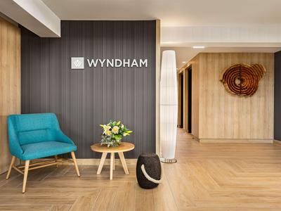 Modern eingerichteter Hotellobby-Bereich mit blauem Sessel, Couchtisch und blühendem Blumenarrangement