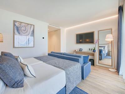 Modernes Schlafzimmer mit Doppelbett, blauen Akzenten, großem Spiegel und Wandfernseher.