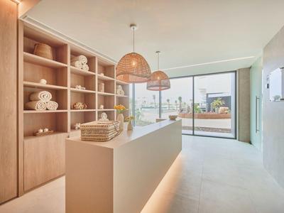 Heller moderner Raum mit Holzregalen, weißen Möbeln und großen Fenstern zur Terrasse.