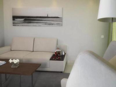 Helles Wohnzimmer mit beigem Sofa, Holztisch und schwarz-weißem Wandbild