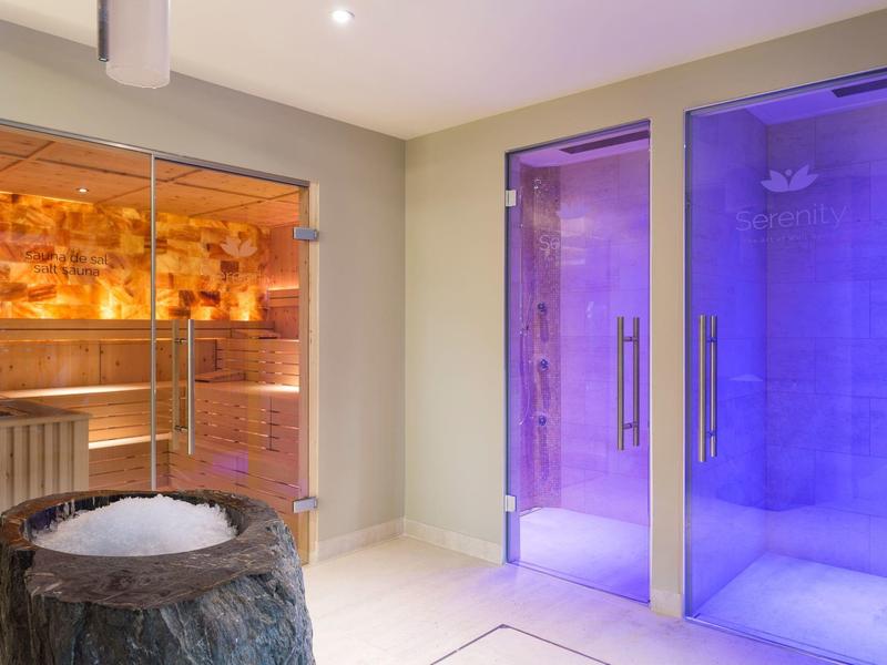 Moderner Wellnessbereich mit Sauna aus Holz, Dampfbädern mit blauer Beleuchtung und Eisbrunnen.