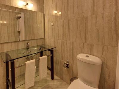 Modernes Badezimmer mit Toilette, Waschbecken und großem Spiegel an der Wand.