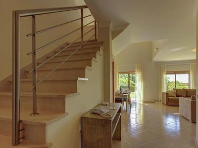 Helles Wohnzimmer mit Treppe, großer Fensterfront und moderner Einrichtung