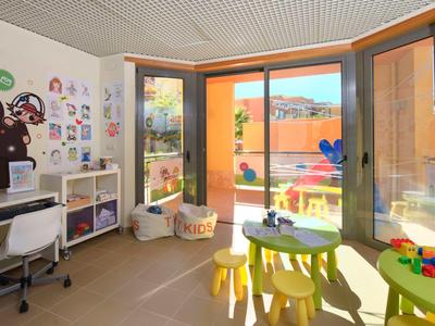 Ein heller und bunter Kinderspielraum mit kreativem Wanddesign und Terrasse.
