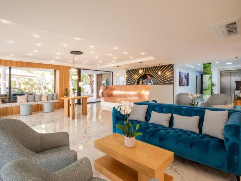 Modern hotel lobby with comfortable seating and bright marble flooring.