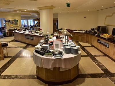 Moderne hotel lounge met buffetstation en gedekte tafels in een lichte ambiance.