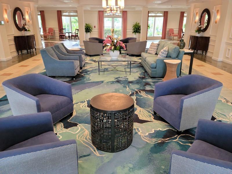 Elegant lounge area with blue armchairs and carpet in a hotel with daylight.