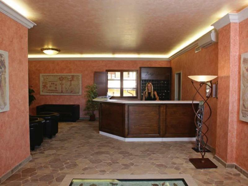 Innenraum mit orangefarbenen Wänden, Deckenlampen, Theke und einem Wandbild auf dem Fußboden.