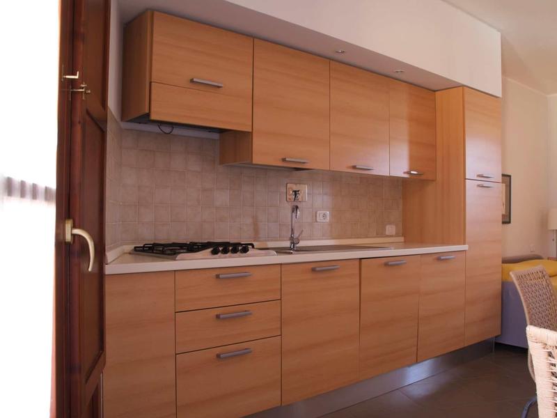 Moderne Küche mit Holzschränken, grauer Fliesenrückwand und gasbetriebenem Kochfeld.