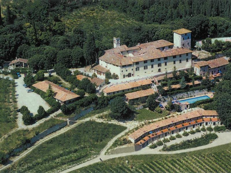 Großes Landhaus mit Pool, umgeben von Weinbergen und dichtem Wald, bei sonnigem Wetter.