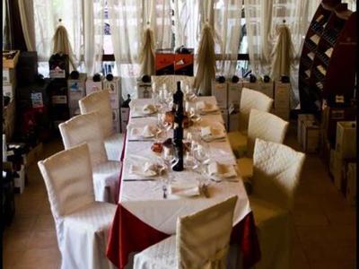 Festlich gedeckter Esstisch in einem warm beleuchteten Restaurant mit Stühlen in weißen Hussen.