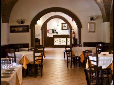 Gemütliches Restaurant mit Holzmöbeln, gedeckten Tischen und gewölbter Decke.