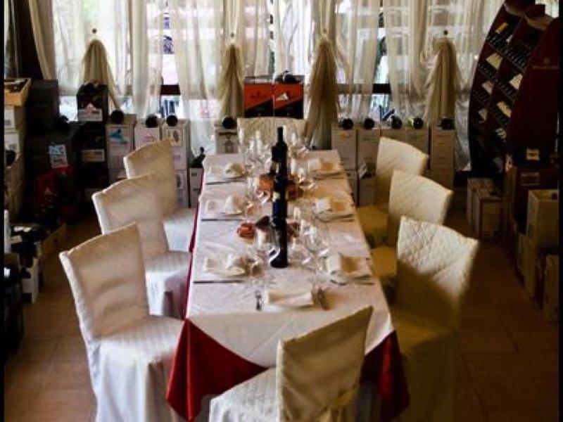 Eleganter Esstisch mit weiß gedeckten Stühlen, Kerzen und gedeckter Tischdecke in warmem Raum.