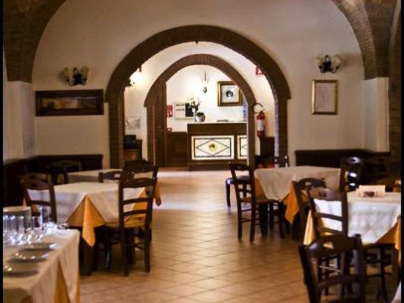 Gemütliches Restaurant mit Holzbalkendecke, Rundbögen, Tischreihen und braunen Stühlen.