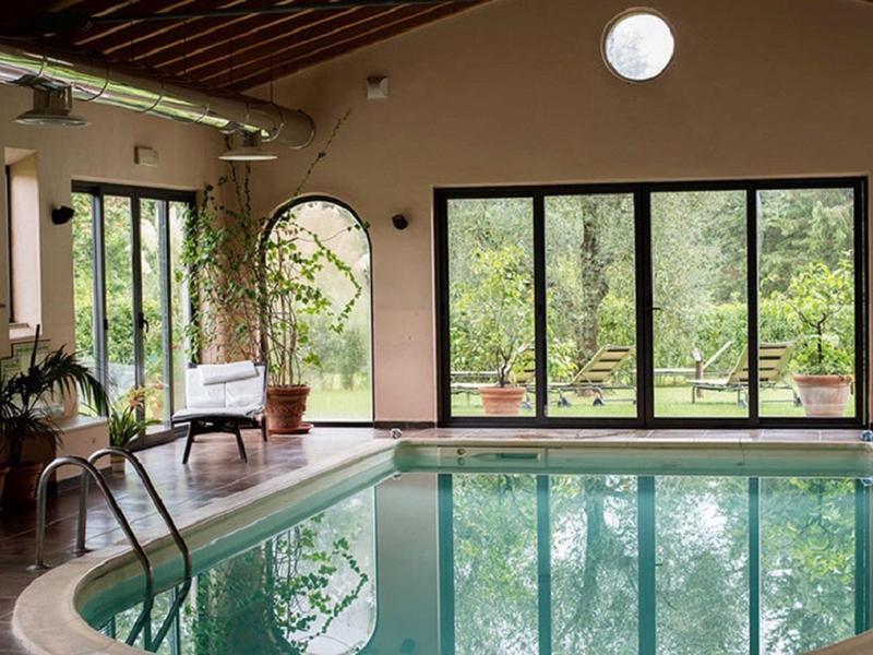 Jasny pokój z basenem krytym, dużymi oknami i roślinami w hotelu.