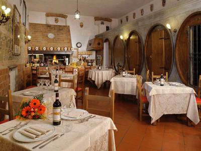 Pohodlná restaurace s dřevěným nábytkem a velkými vinnými sudy na stěně.