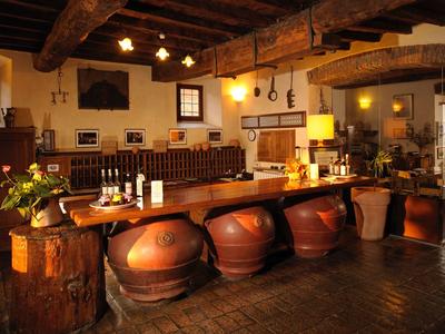 Bar rustica dell'hotel con grandi vasi di terracotta come sgabelli e illuminazione calda