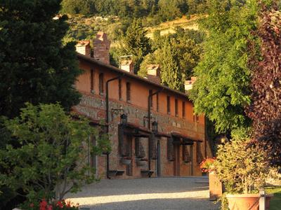 Edificio rustico in pietra e legno circondato da alberi alla luce del sole.