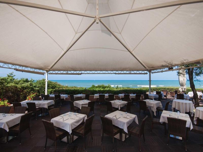 Ristorante all'aperto con area coperta e vista sul mare alla luce del giorno