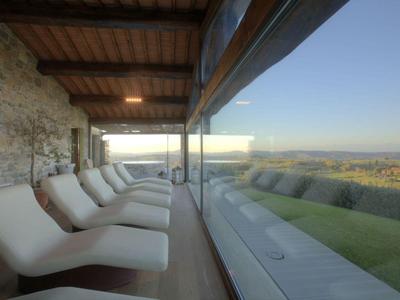 Moderní lounge s pohodlnými lehátky a panoramatickým výhledem na zelené údolí.