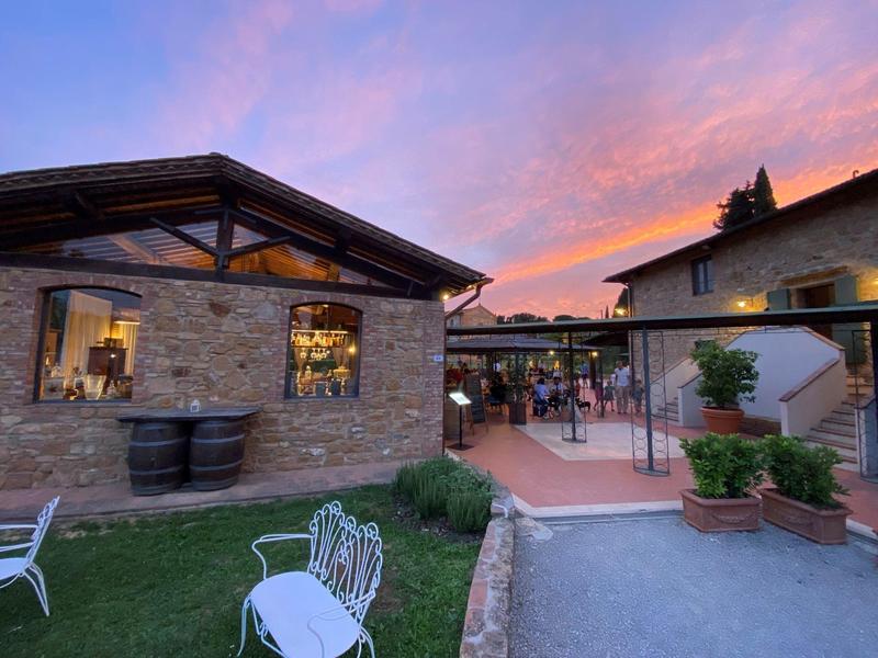 Příjemná venkovní část hotelu s posezením a barevnou večerní oblohou.