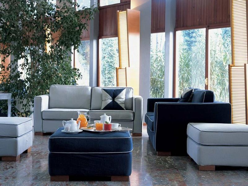 Bright hotel lounge with seating area, large windows, and plants.