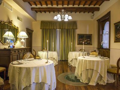 Elegant dining room with round, white-covered tables in a traditional style.