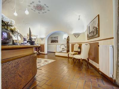 Jasna recepcja hotelowa z antycznymi meblami i dekoracyjną podłogą.