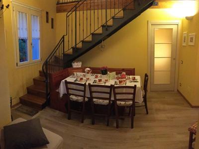 Cozy dining area with a set table under a staircase in warm lighting.