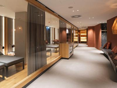 Moderner Hotelkorridor mit Sitzbereichen, warmem Licht und eleganter Einrichtung.