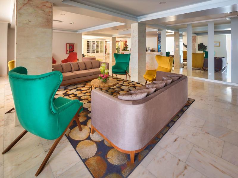 Hall d'hôtel moderne avec fauteuils colorés, canapés et éclairage lumineux