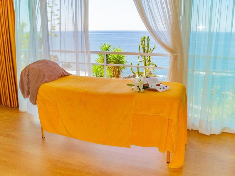 Table de massage lumineuse près d'une fenêtre avec vue sur la mer, lumière naturelle douce.