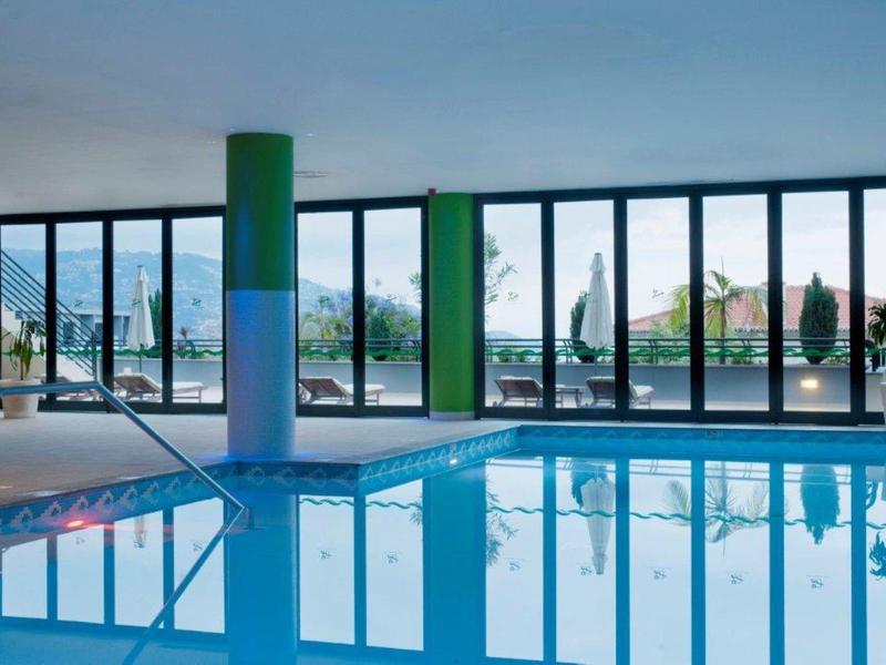 Área interior con una gran piscina y ventanas panorámicas que muestran el exterior.