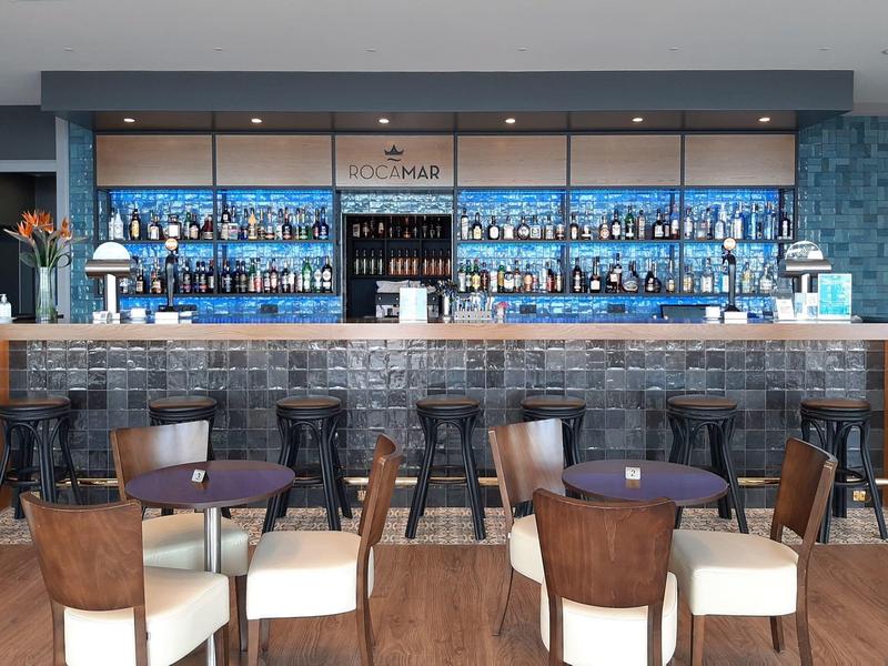 Moderní hotelový bar s koženými křesly a širokým výběrem lihovin.