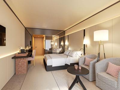 Modern eingerichtetes Hotelzimmer mit Doppelbetten, Sesseln und Schreibtisch.