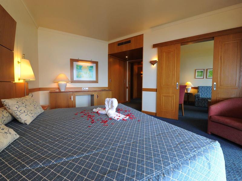 Cozy hotel room with large bed, armchair, and modern lighting.