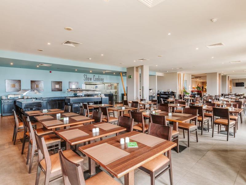 Spacious hotel breakfast room with many tables and chairs.