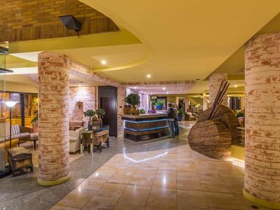 Helle Hotellobby mit runden Säulen, modernem Tresen und dekorativen Elementen aus Holz.