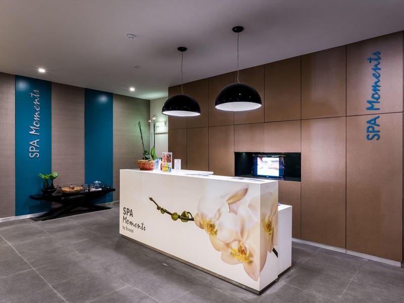 Moderní recepce s bílým pultem a květinovým motivem v hotelu spa.