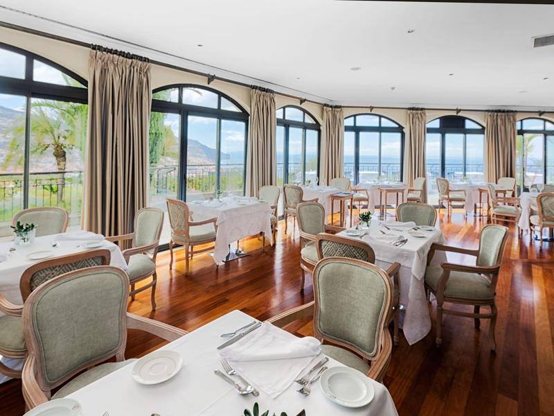 Světla restaurace s velkými okny a výhledem na zelené hory