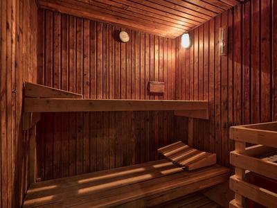Sauna acogedora con banco de madera y luz cálida para relajación en el hotel.