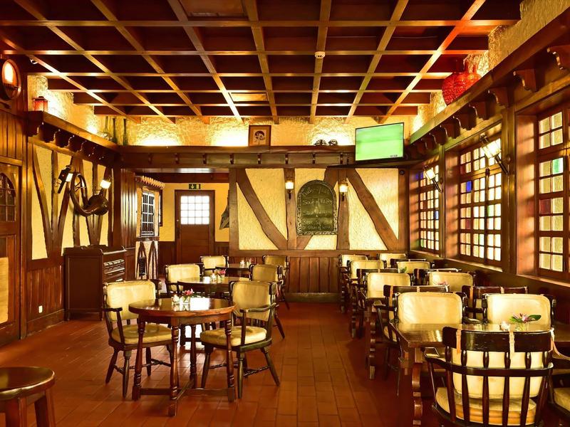 Gemütliches, rustikales Restaurant mit Holztischen, Stühlen und warmem Licht, Fachwerk an der Wand.